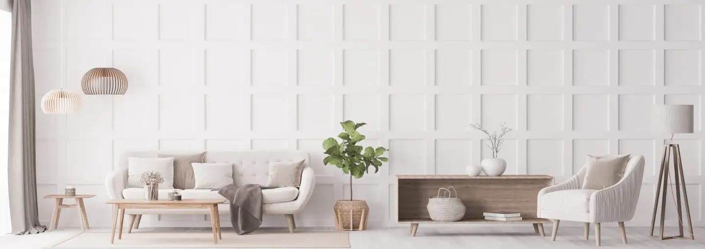 Modern living room with white paneled walls, neutral furniture, a sofa, armchair, coffee table, floor lamp, plants, and minimalist decor.